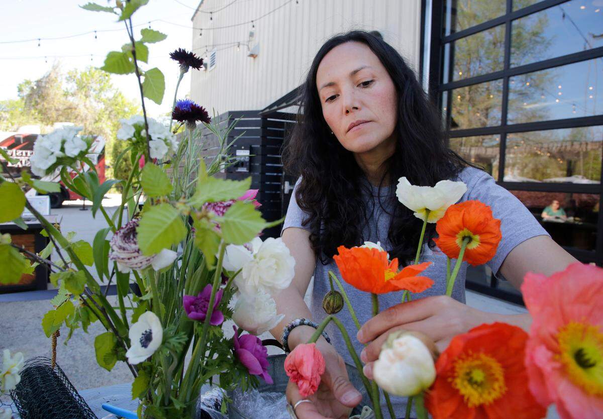 Angelica Tupper of Five Blossoms Farm arranges flowers Saturday during the Blooms, Boards and Brews event at Slow Play Brewing in Rock Hill.