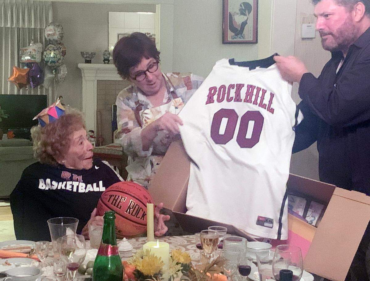 Dorothy Jones, left, looks at a basketball jersey sent to her by the Rock Hill school district to celebrate her 103rd birthday.
