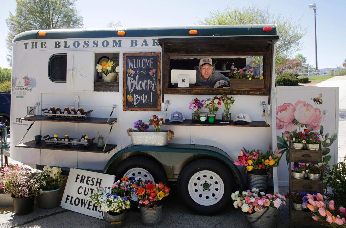 John Tupper of Five Blossoms Farms stands in the company’s Blossom Bar, which a mobile flower shop on Saturday.