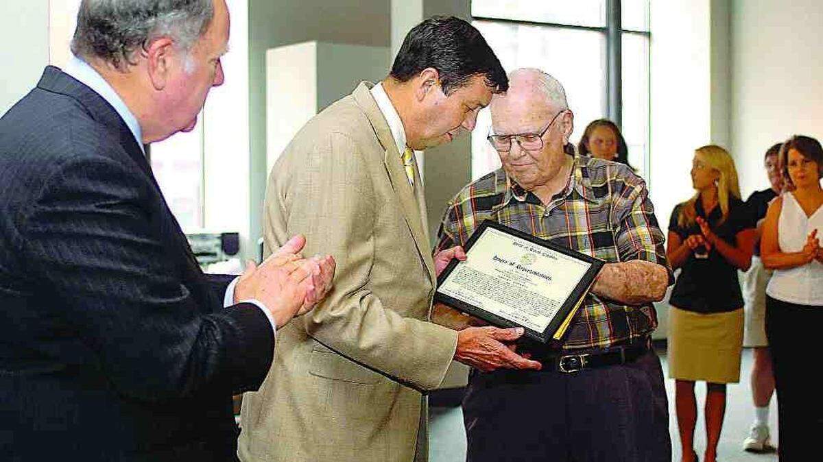 U.S. Rep. John Spratt, D-S.C., and others applaud as state Rep. Herb Kirsh, D-Clover, right, presents Robert Hopkins with an award from the state House of Representatives honoring his service as Spratt’s district coordinator.