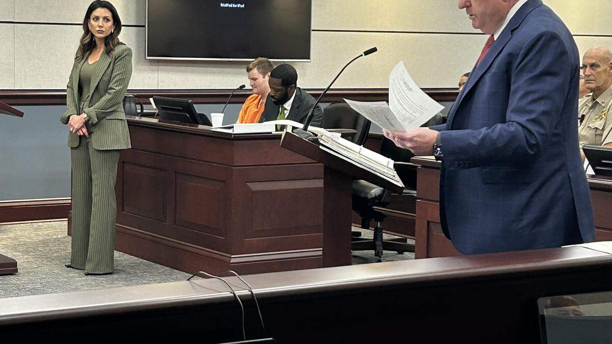 Zachary East Elias, seated in orange, in York County criminal court on Sept. 15, 2025. The 16th Circuit solicitor at right explains the murder and other charges against Elias as his lawyers stand and sit with Elias.