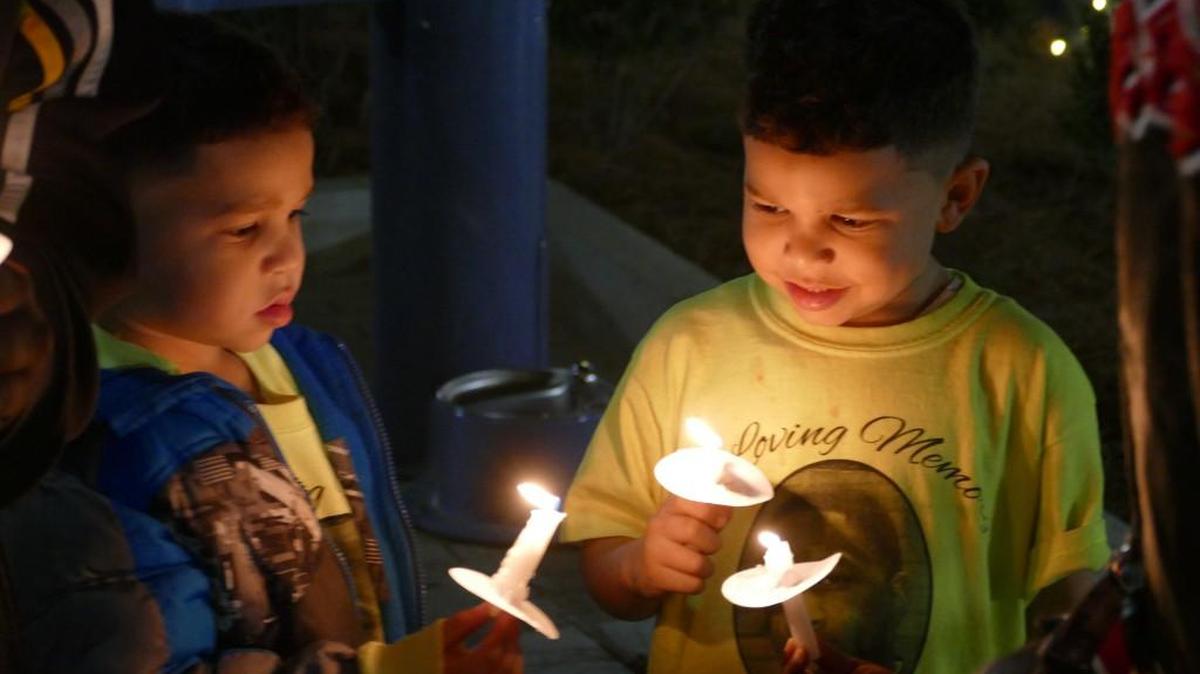 Trenton Heath, left, and his twin brother Anthony light candles at a vigil for their father, Antonio Heath, who was shot to death at the door of their Rock Hill home Nov. 24, 2014. Many in attendance at Tuesday’s vigil also wore shirts bearing Heath’s picture.