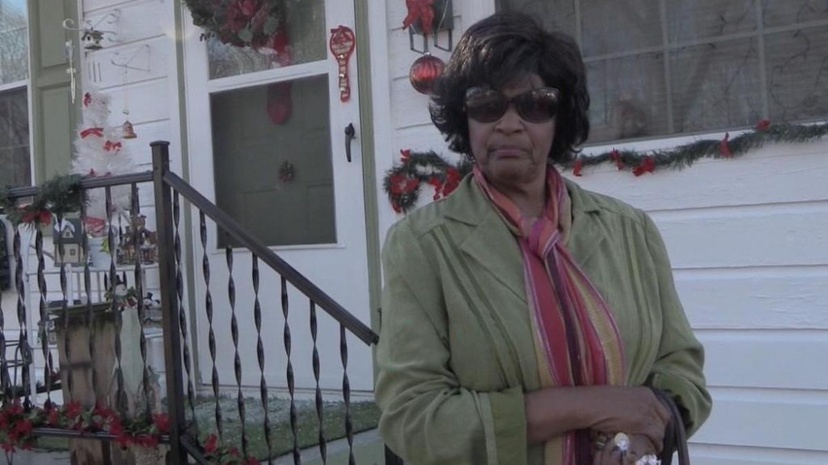 Marguerite Moore in front of her Harrison Street home.