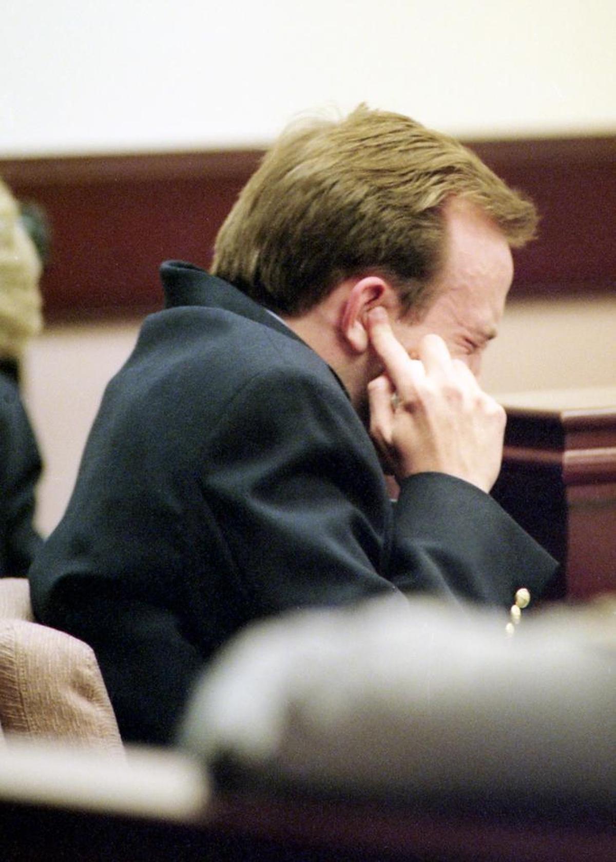 James Robertson holds his fingers to his ears to avoid hearing the death sentence during his 1999 trial in York.