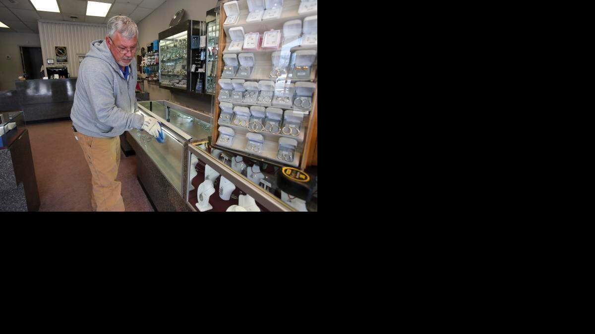 
 Lee Holder with Rock Hill Glass works on repairing a glass display case that was broken during the robbery at Norman Hege Jewelers.
