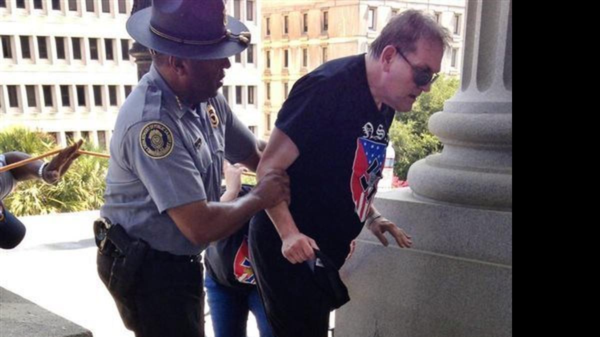 
S.C. Department of Public Safety Director Leroy Smith helps someone wearing National Socialist Movement attire get to shade and water during a Ku Klux Klan rally Saturday at the State House.
