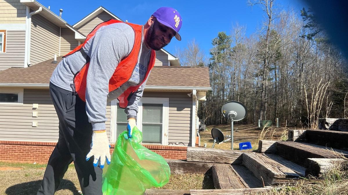 Northwestern athletic director Caleb Gaither goes to pick up a discarded soda can.