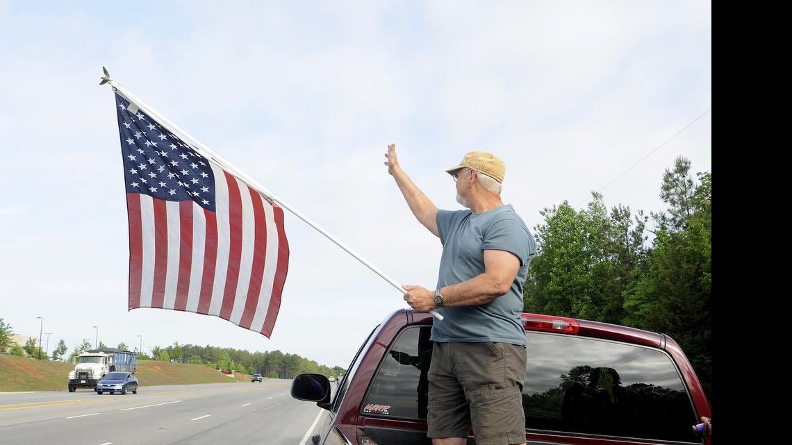 
Keith Lyon waves to drivers along the S.C. 5 Bypass Thursday morning during a flag protest outside York Comprehensive High School. Dozens of students and adults lined up along the road in protest of a York student who was told to remove an American flag from his vehicle.
