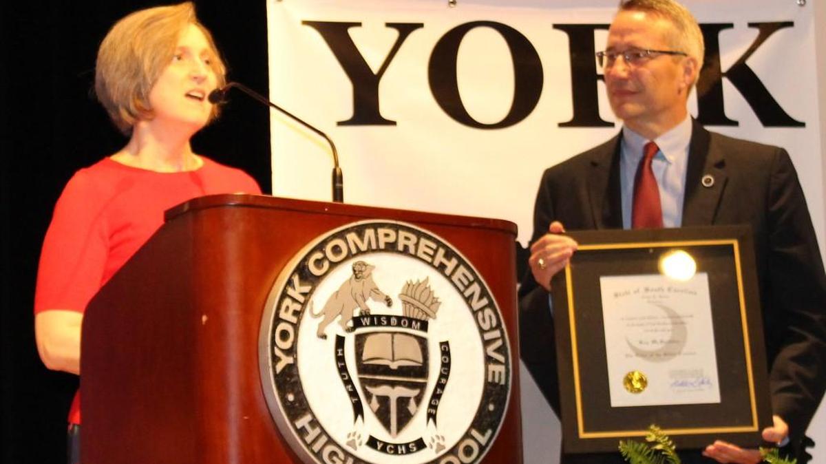 Kay McSpadden, an English teacher at York Comprehensive High School, speaks upon receiving the Order of the Silver Crescent during Friday's York school district back to school celebration for teachers. At right is S.C. Rep. Tommy Pope, R-York.