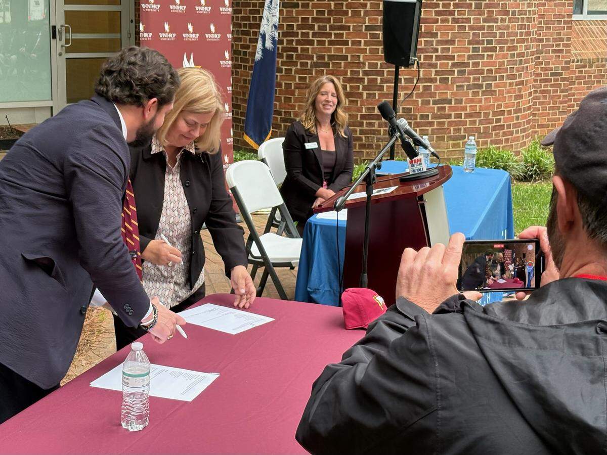 Winthrop University Board of Trustees Chairman Joel Hamilton and Fort Mill Mayor Guynn Savage sign an agreement to work together to bring a school campus to Fort Mill.