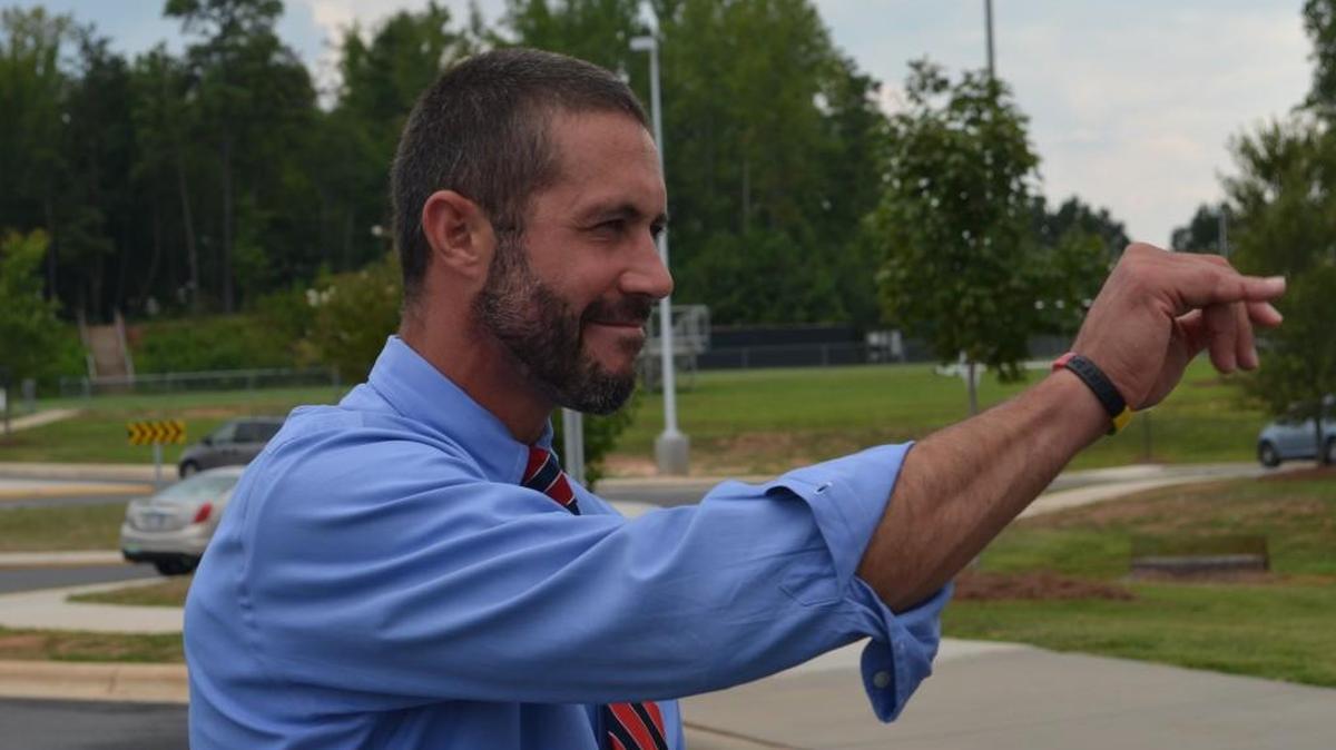 
Jason Johns, the new principal at Nation Ford High School in Fort Mill, waves to parents as they pick up their children Monday. 
