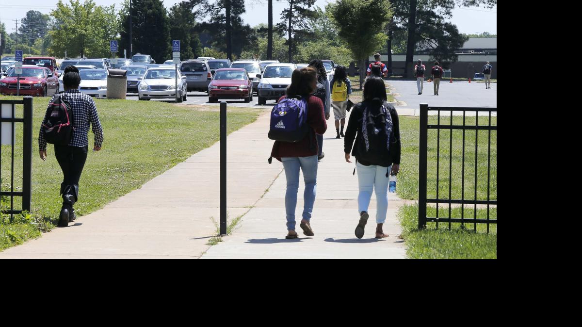 
Students at Northwestern High School walk past a small decorative fence that will be replaced with a taller fence and gate that can be locked.
