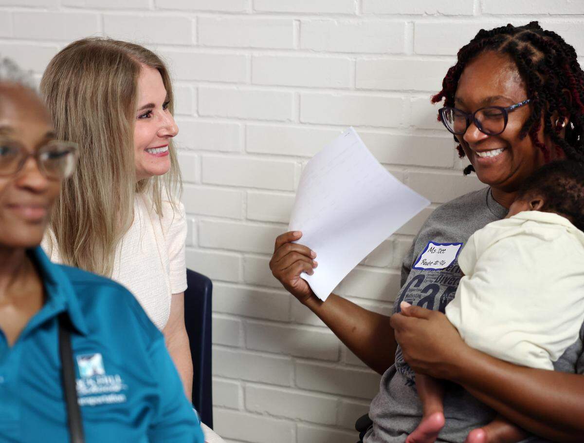 Rock Hill School District Superintendent Deborah Elder, left, talks to bus driver Dee Williams as she holds Emoree Pittman last week.
