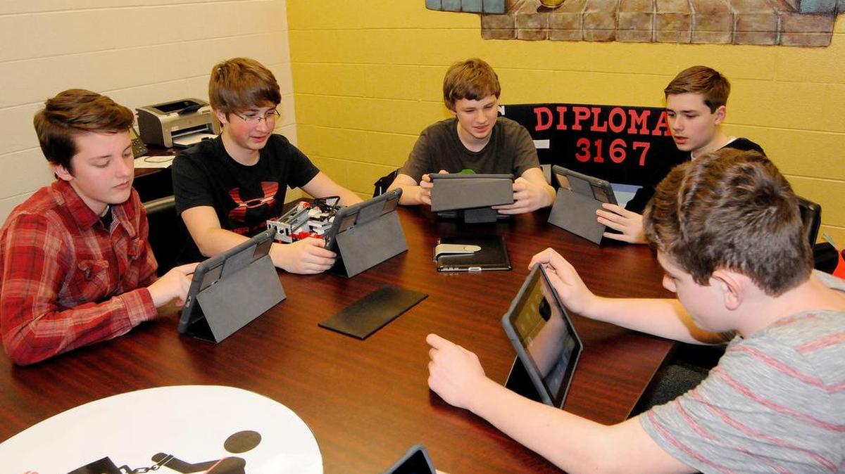 Oakridge Middle School robotics team members Malcolm Addison, from left, Nico Marsilio, Matthew Kingswood, C.J. Stafenco and Chase Hernandez work on their “bottle bill” research project. They are writing a proposal for state legislation that would create a rebate for people who recycle aluminum cans.