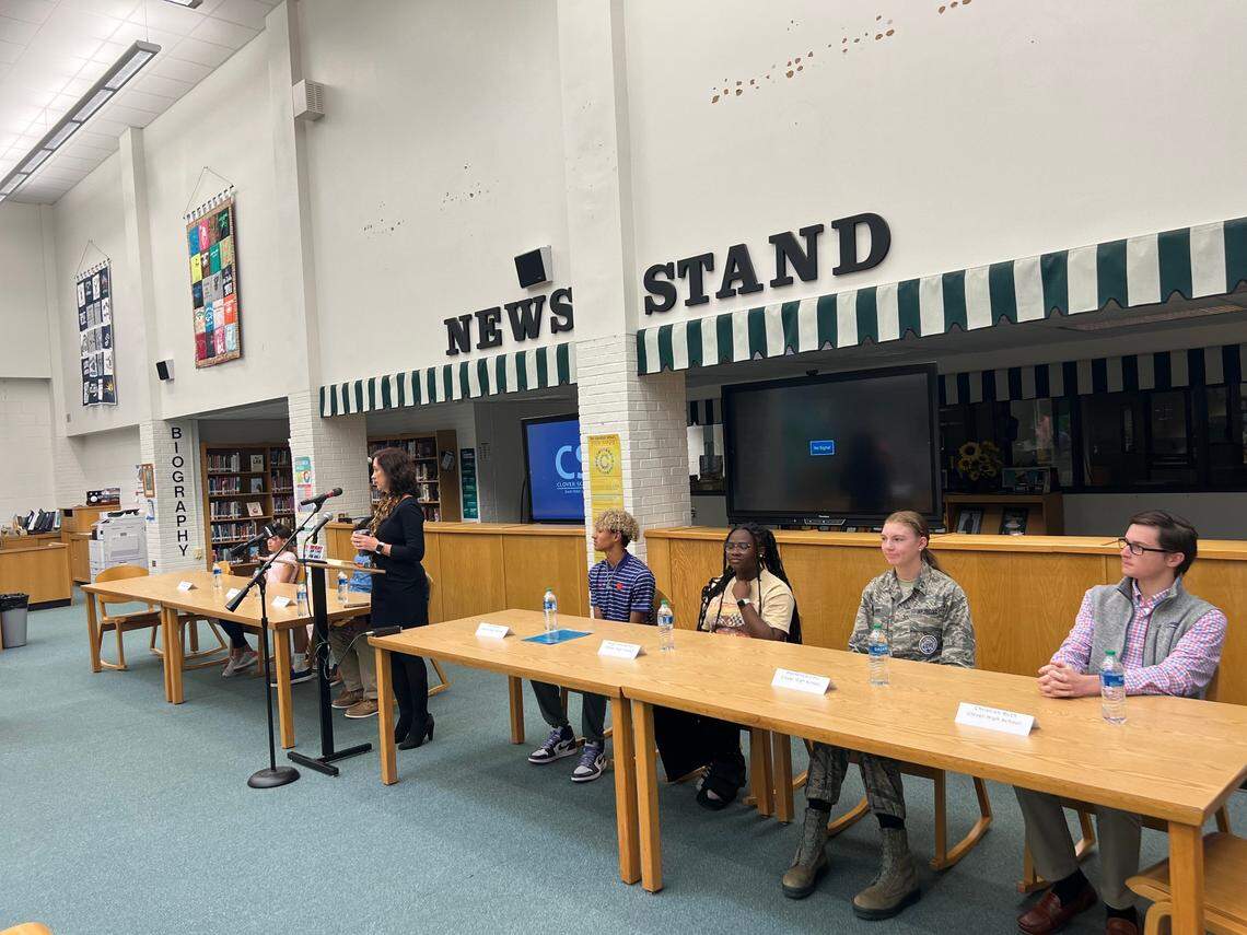 Clover School District superintendent Sheila Quinn (middle) is standing in between Oakridge Middle School students (seated left) and Clover High School students (seated right) at a media event at Clover High School on Oct. 19.