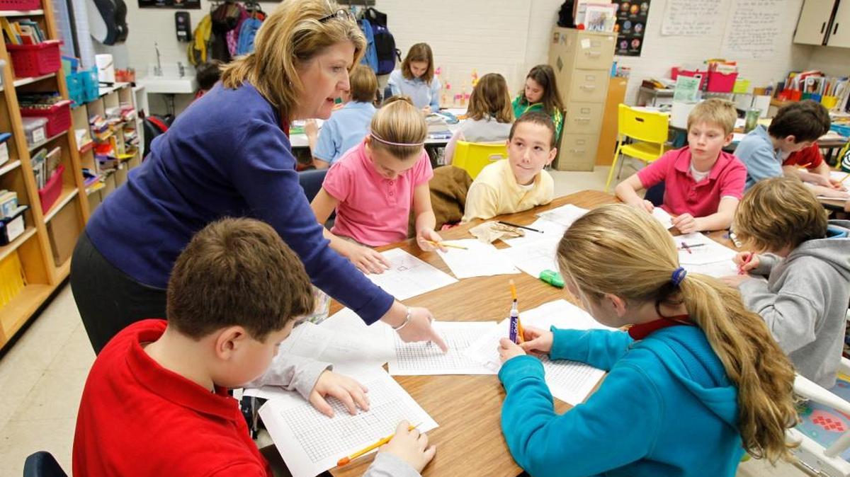 Teacher Mary O'Grady-Jones works with students during a math class in her fifth-grade gifted and talented class at Sunset Park Elementary School. Sunset Park is one of seven schools of choice.