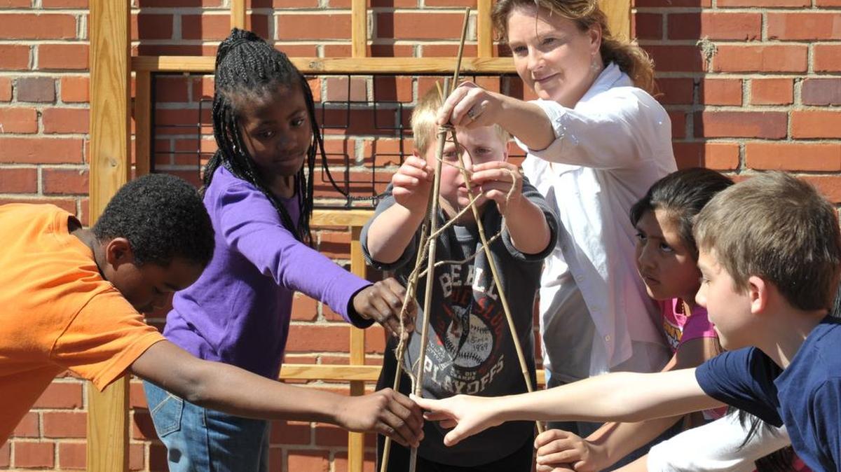 In this 2014 file photo, fourth-graders work in the garden at Ebinport Elementary with garden coordinator and School Improvement Council member Kelly Sebastian. The garden is intended to teach students to make connections to the food they eat.