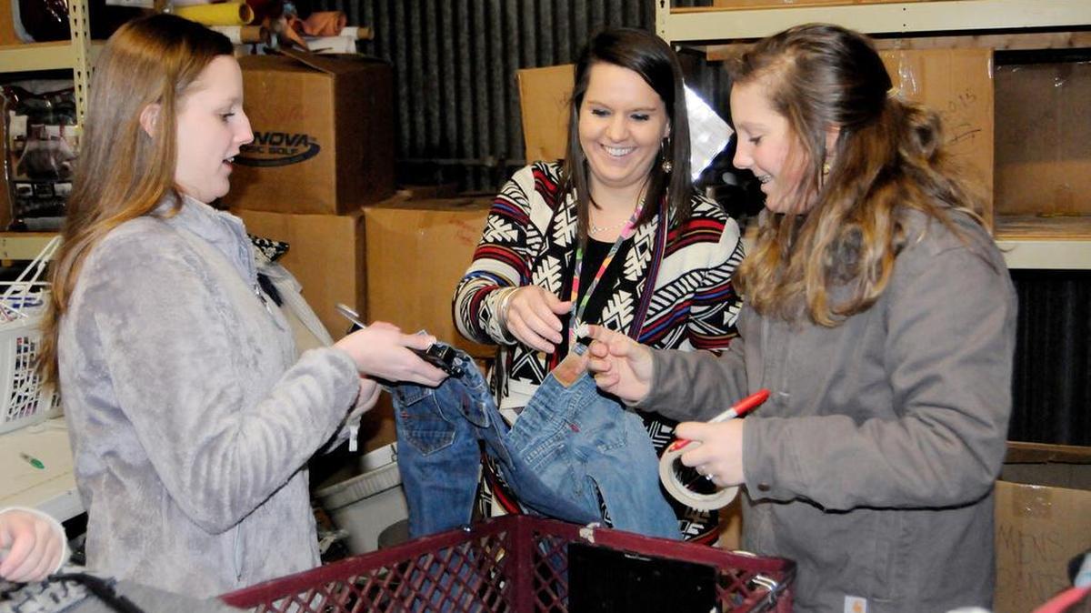Clover High School student Chloe Moore, from left, with teacher Hannah Bryant and student Jessie Comer, both from York Comprehensive High School, sort clothing at the Tender Hearts thrift store in York.