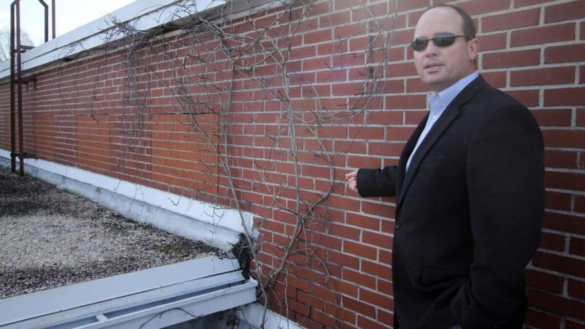 Brian Vaughan, director of facilities services for the Rock Hill school district, shows vines that are growing on the roof of Edgewood Center, which houses the Head Start program.