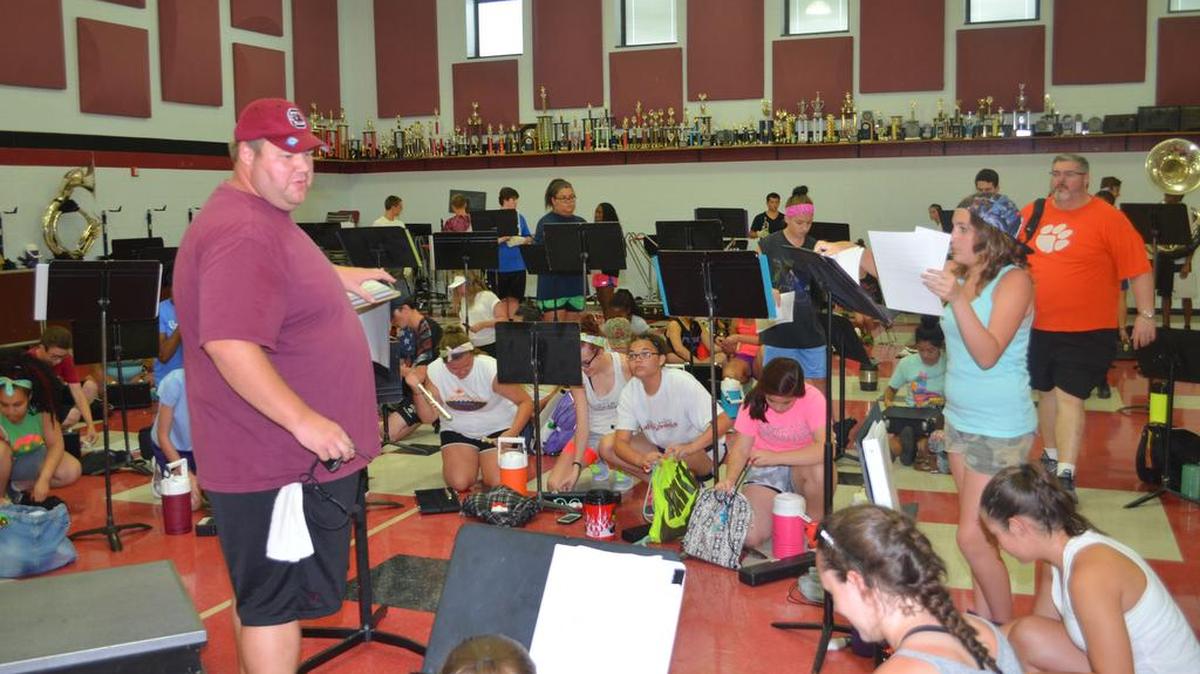
Director Ben Hingle talks to his marching band students at Rock Hill High School during band camp. 
