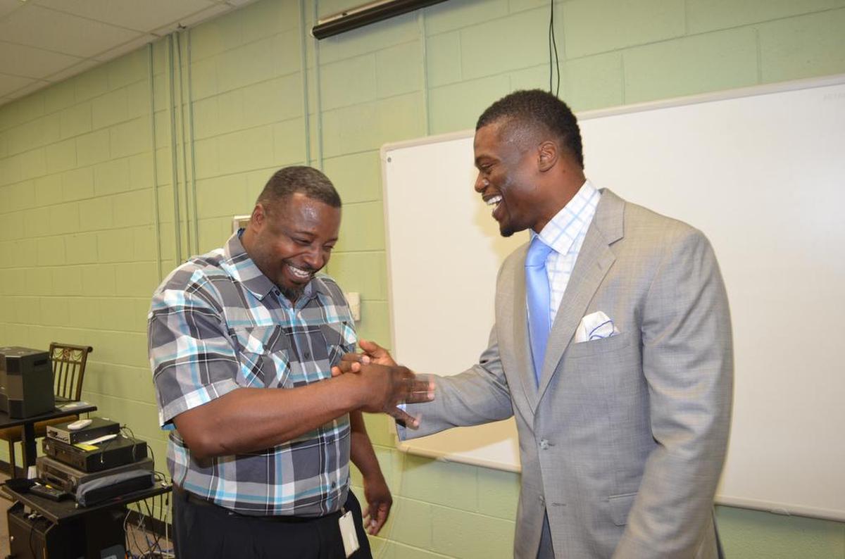 Benjie Young shakes hands with his friend Ben Watson, following Tuesday’s announcement that Watson has created a $10,000 endowment for the Rock Hill Schools Education Foundation.