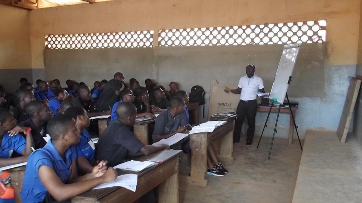 Gerald Kwake uses a whiteboard in his Cameroon classroom. He bought g two portable whiteboards, a microscope and other equipment with a Rock Hill woman’s gift.