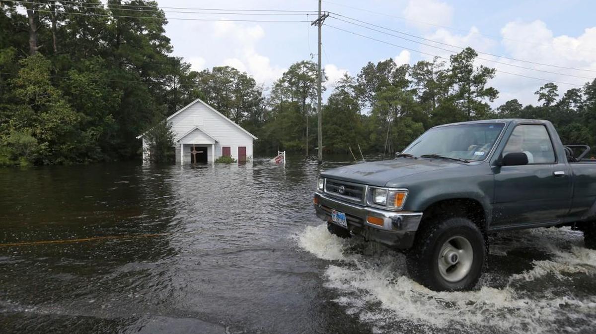 A truck driver moves through high water in front of a flooded church in the aftermath of Tropical Storm Harvey in Vidor, Texas, Sunday.