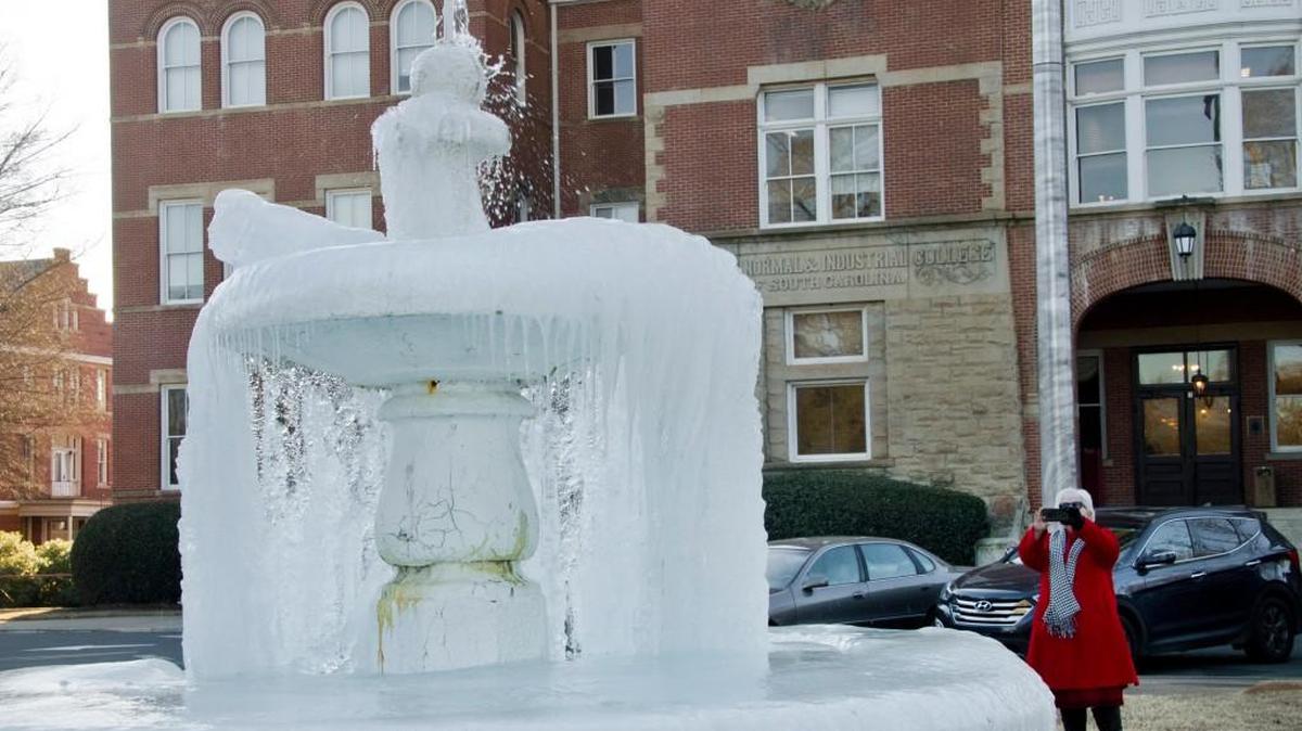 Winthrop University Provost Debra Boyd takes a photo of the frozen fountain at the university on Tuesday. Freezing temperatures continued Wednesday.