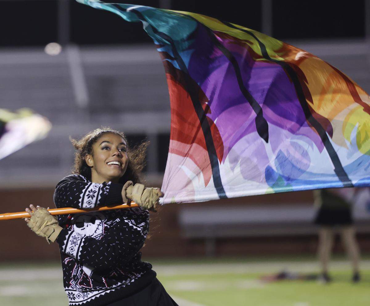 A member of the Pride of Clover Marching Band color guard performs at Clover Memorial Stadium. The band will march at the Rose Parade in Pasadena, Calif. on New Year's Day.