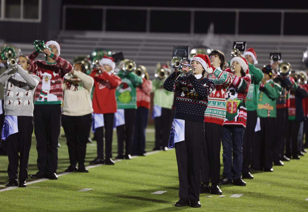 Clover band members wear holiday attire for a community performance ahead of their New Year’s Day plans to march in the Rose Parade.