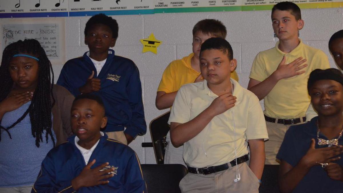 
Students in the 6th-grade chorus at Saluda Trail Middle School stand and salute the American flag during a video featuring Lee Greenwood’s “God Bless the USA.”
