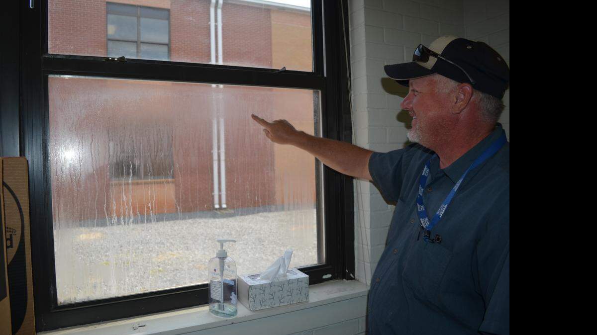 
Dwayne Gaston of the maintenance staff at Sullivan Middle School points to the cloudy windows, caused by cracks in the seals between the two panes of glass. The proposed bond package calls for money to replace windows at Sullivan Middle and other schools. 
