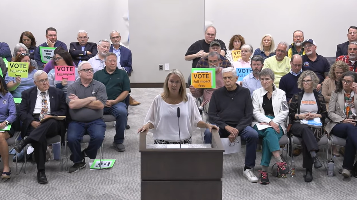 Fort Mill school board Chairwoman Kristy Spears, backed by supporters of higher impact fees for the Clover School District, addresses the York County Council on Oct. 20. Several Fort Mill residents are asking York County to help the Clover district raise its fees.
