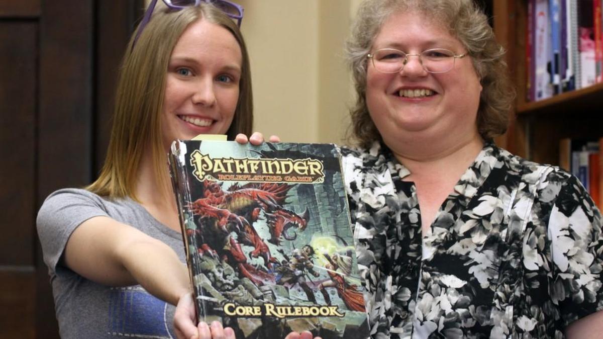 Krysten Hudson, left, and writing instructor Christina Stiles show off a role playing game they used during a gaming class at Winthrop University.