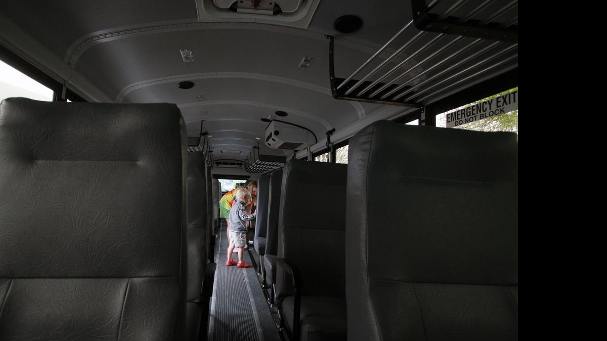
Grace Boyd, 8, and Alex Boyd, 3, walk through Rock Hill school district’s newest activity bus at the Come-See-Me Festival’s Everything Trucks event. Officials hope to replace the older buses over the next 5 years.
