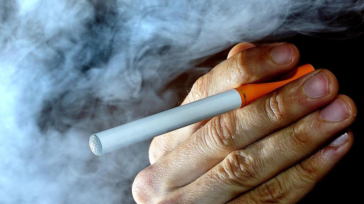 File- This June 12, 2013, file photo shows a person posing with an electronic cigarette, or e-cigarette.