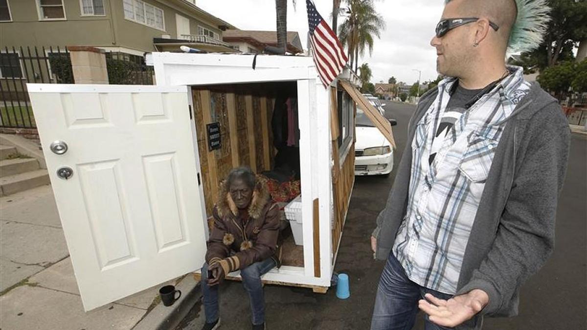Los Angeles resident Elvis Summers, right, poses with his tiny house on wheels he built for Irene "Smokie" McGhee, 60, had been sleeping on the streets in his South Los Angeles neighborhood. The house is small enough to fit in a parking space.