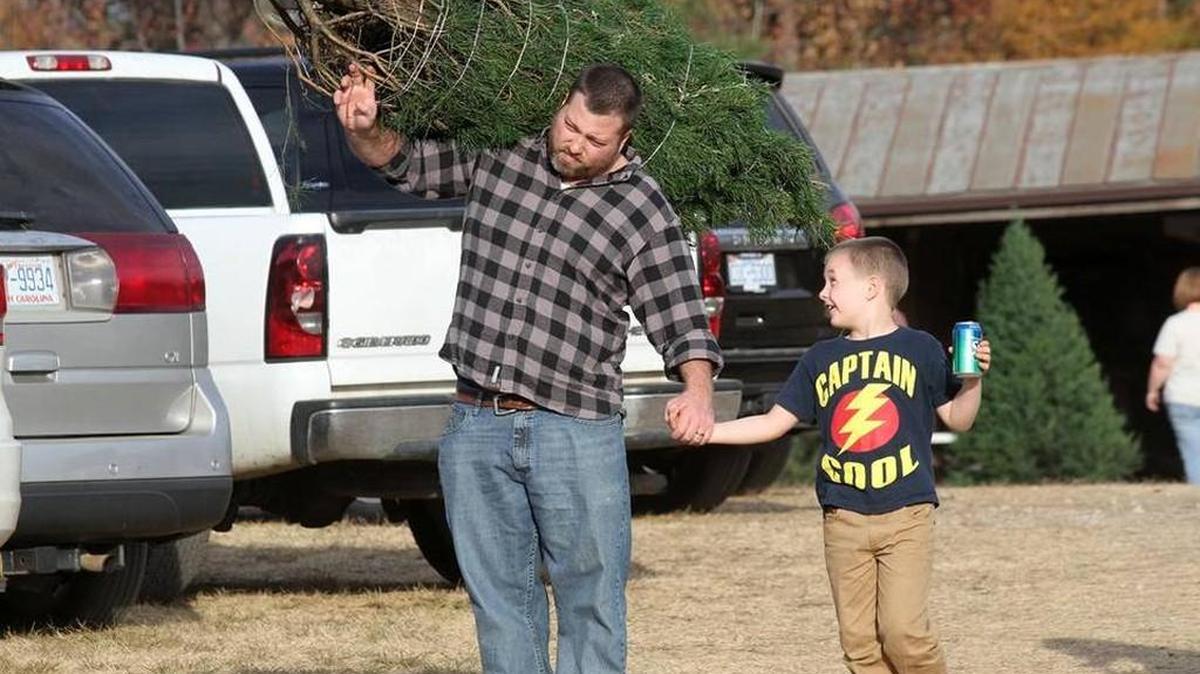 Visitors at Penland Christmas Tree Farm in York County walk to their car with a new tree earlier this month.
