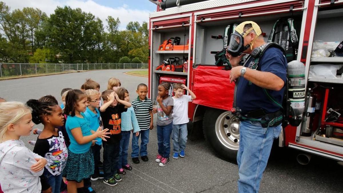 
Firefighters with the Lesslie Volunteer Fire Department visited Independence Elementary in Rock Hill Monday to discuss fire safety with the students. The students got to tour two fire trucks, look at firefighting equipment and spray water from a firetruck with Sparky the Fire Dog. John Boyd with the Lesslie Fire Department demonstrates to kindergarteners breathing equipment that firefighters use when entering a burning building.
