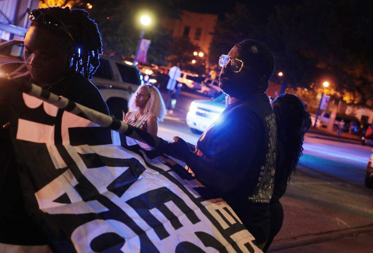 A protester holds a Black Lives Matter flag Thursday during a protest at the Rock Hill Police Department.