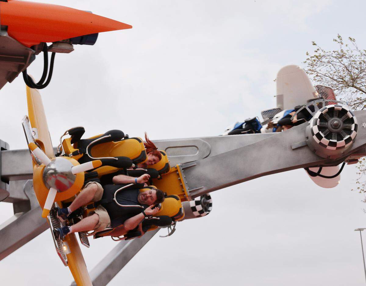 Riders scream Thursday on the Air Racers attraction at Carowinds’ new Aeronautica Landing.