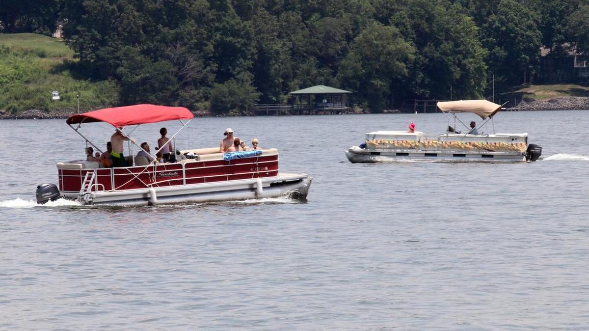 Pontoon boats ride by Ebenezer Park on Lake Wylie Saturday.