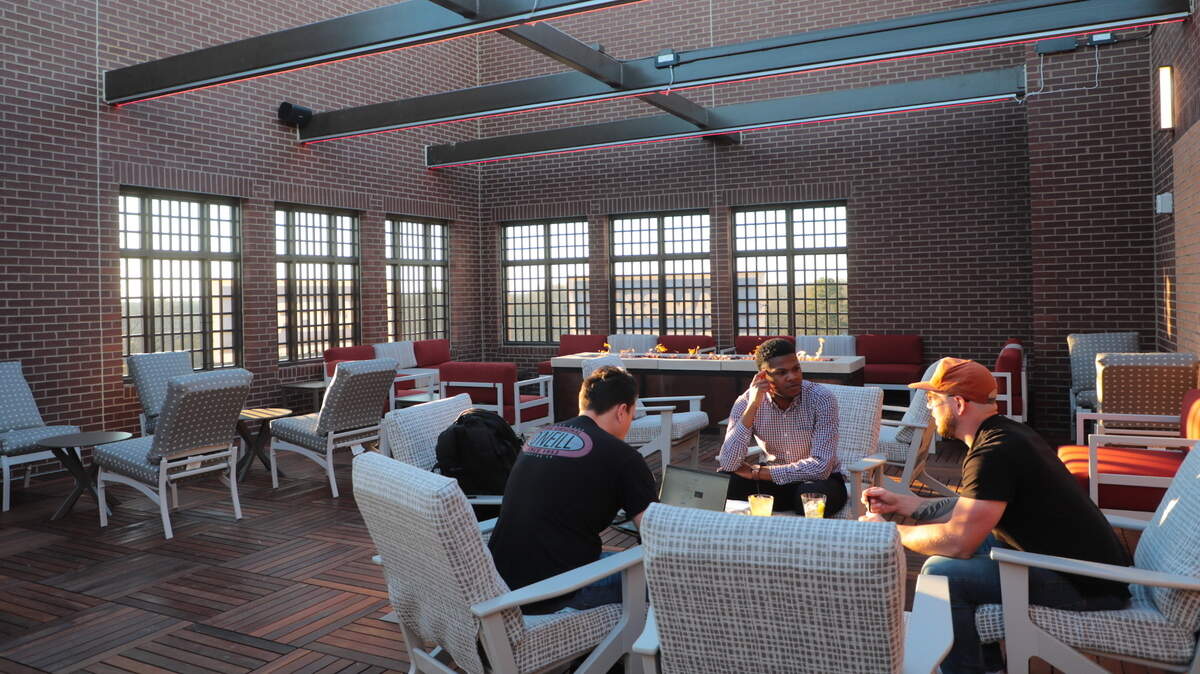 From left, Jordan Herring, Tadean Page and Ryan Sanderson talk at the 354 SkyBar atop the Cambria Hote in historic Rock Hill in early 2021. Cambria is a filming location for the Church + Main project.