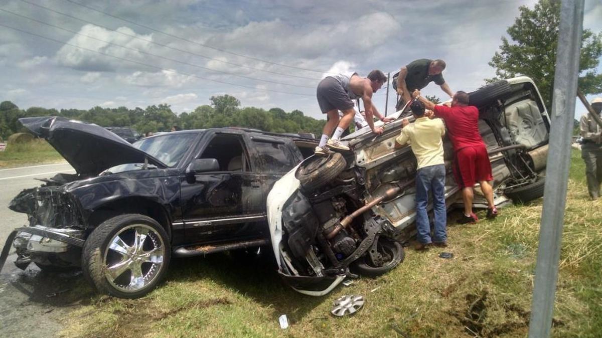 Bystanders attempt to force open the overturned car carrying Truc Tran and two other people in Rock Hill on Sunday. A medical professional on the scene says not to attempt to move injured crash victims if you aren’t trained to do so.