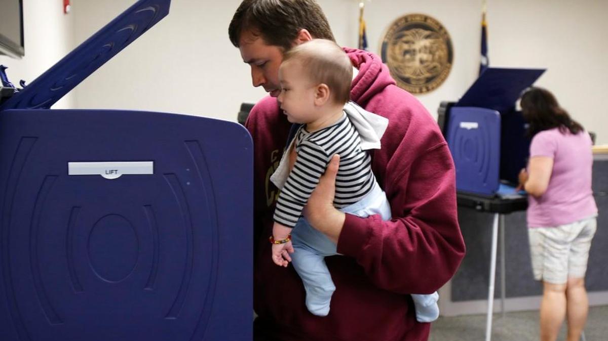 Matthew Meehan votes in Fort Mill on Tuesday, while holding his son Merek, 4 months old.