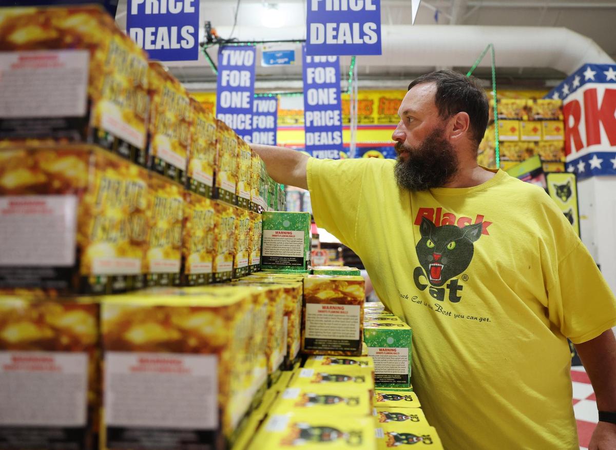 Eric Park adjusts a shelf of fireworks Wednesday at Red Rocket in Fort Mill.