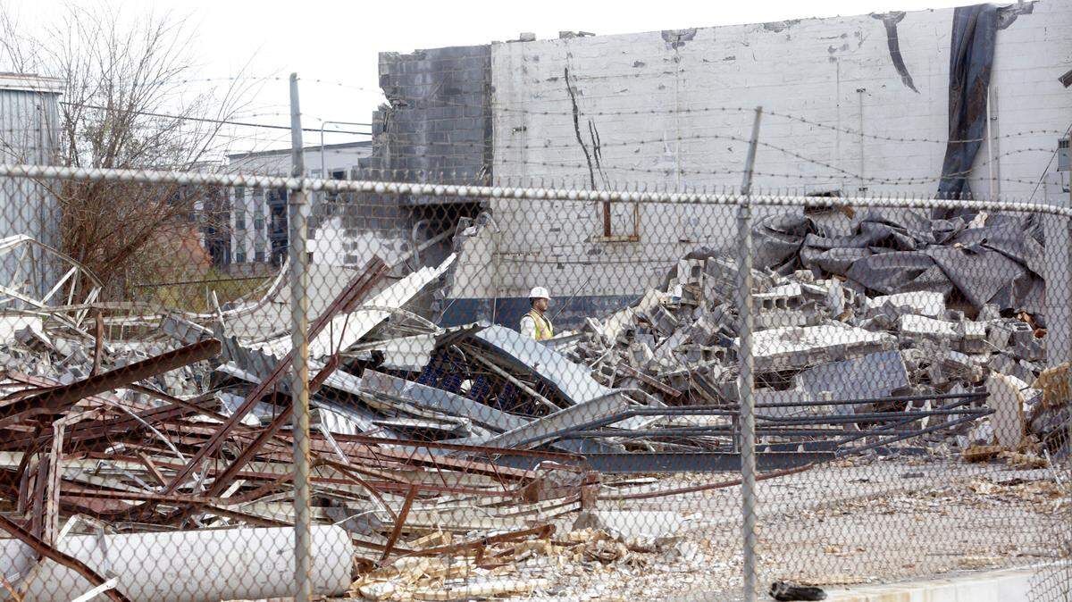 In this file photo from demolition in 2022, Samael Canales walks among construction debris at the former Herald offices on West Main Street in Rock Hill.