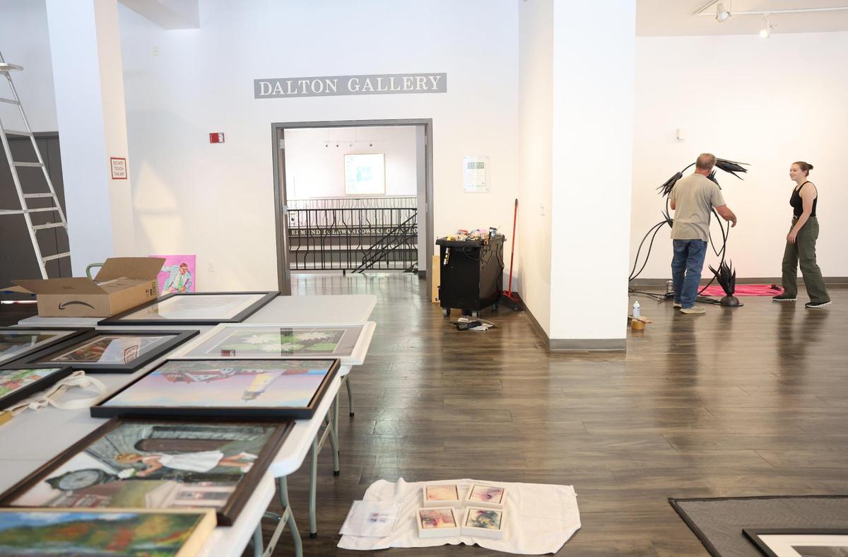 Artist Randy Weiss, left, and Annie Heisel, Center for the Arts gallery manager, install a sculpture Tuesday at the center in Rock Hill. Federal funding cuts for the arts haven’t significantly impacted Rock Hill.