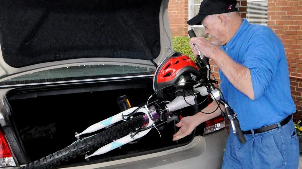 Ernie Wright of York loads a bicycle into a car for a family that is receiving Christmas gifts for children through the Holiday Partners program.
