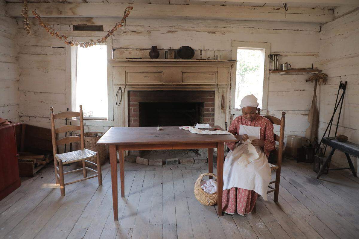 Interpreter Oriana Moore demonstrates her trade as seamstress Saturday, Feb. 12, 2022 at Historic Brattonsville, where the historic site is holding “By Way of the Back Door” to tell the stories of people enslaved there during the 18th and 19th centuries.